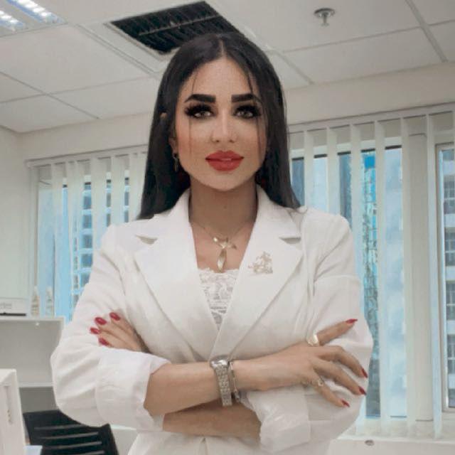 Dr Aida assessing facial proportions in a soft-light mirror